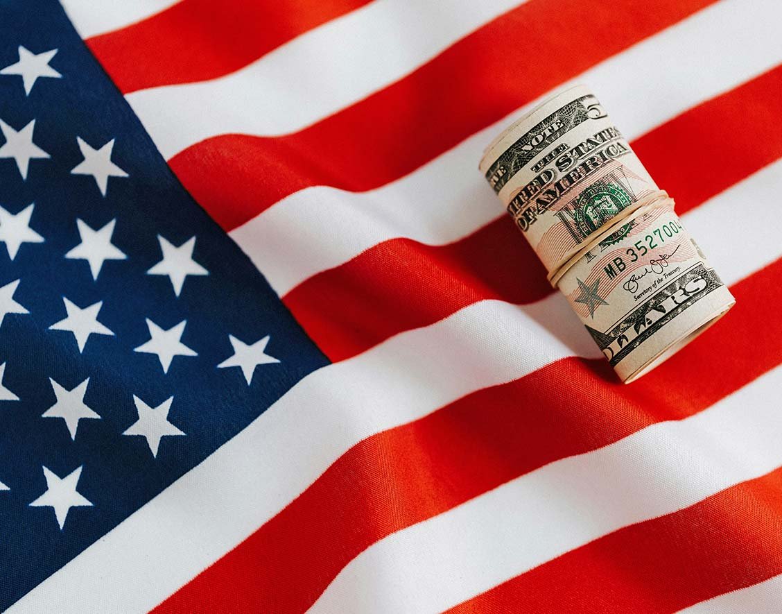 Roll of Dollar Bills on American Flag Roll of Dollar Bills on American Flag